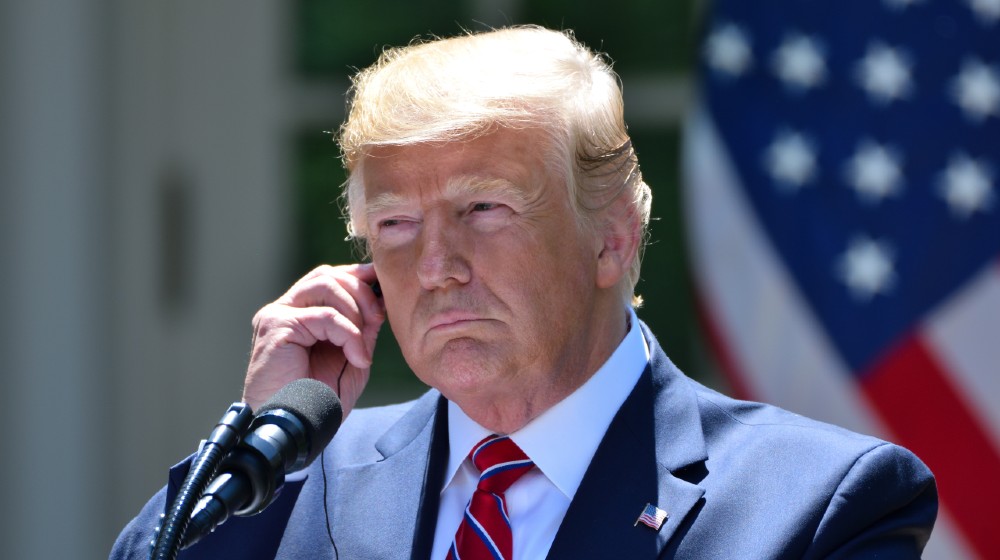 President Donald Trump adjusts his translation earpiece at a joint press conference with Polish President Andrzej Duda in the White House Rose Garden-Trump Suing Brad Raffensperger-ss-featured