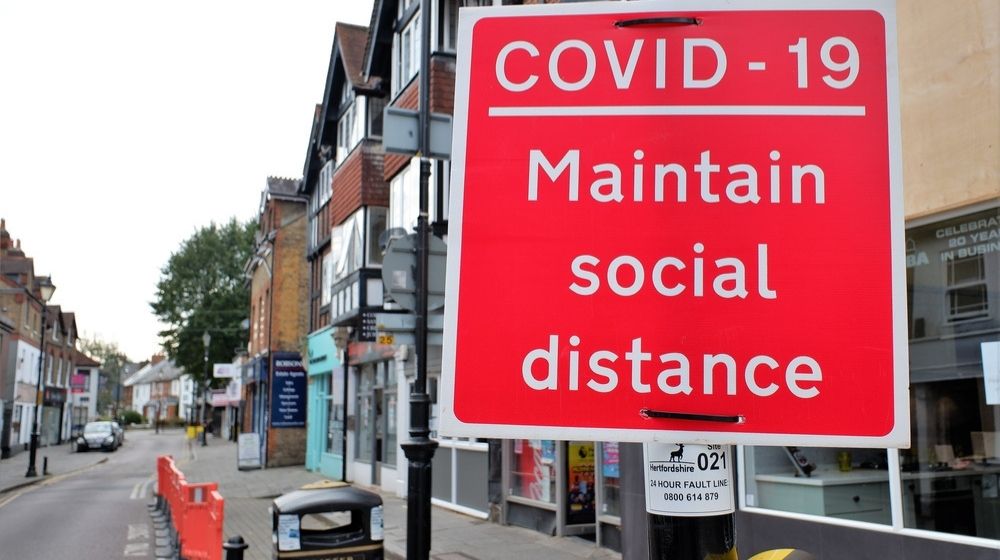 Street sign reminding people to maintain social distance-National Lockdown For England Expected to Last Until Mid-February-ss-Featured