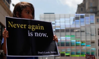 A young girl holds up a protest sign to demand the closure of detention camps at the U.S.-Mexico border-Border Detention Centers-ss-featured