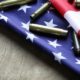 Firearm ammunition on a US flag-Merrick Garland Admits his DOJ Will Advance Joe Biden's Insane Gun Control Agenda -ss-Featured