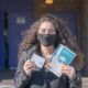 A woman displays her vaccination card and the “IGotTheShotNYC” banner after exiting the NYC Health Department Vaccine Hub-Vaccines By May-ss-featured