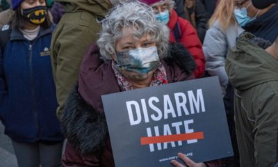 A woman holds a sign that reads _disarm hate_ at a peace vigil to honor victims of attacks on Asians in Union Square Park-Asian Hate-SS-Featured