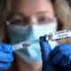 COVID-19 vaccine in researcher hands, female doctor holds syringe and bottle with vaccine for coronavirus cure-Americans Will Refuse-SS-Featured
