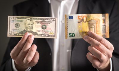 Dollar vs euro. Business man in suit holding 50 banknote and bill in both currency in hand-weak us dollar-ss-featured