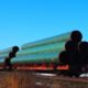 Railway flatcar loaded with large diameter pipe destined for use on the Trans Mountain Pipeline-21 States-ss-featured