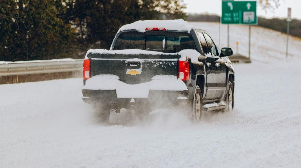 Snow covered road and vehicle in Austin-ERCOT Overcharged Texas Power Companies $16 Billion After Widespread Outages-ss-Featured