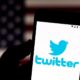 Twitter logo on a smartphone in front of a US flag-Twitter Says Suspension of Rep. Marjorie Taylor Greene was In Error-ss-Featured