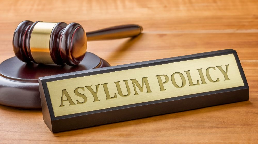 A gavel and a name plate with the engraving Asylum Policy-Asylum System-ss-featured
