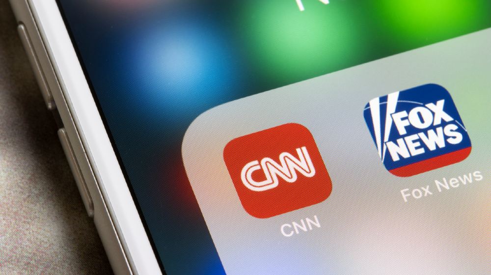 CNN and Fox News mobile app icons are seen on an iPhone. Leaning left (liberal) news versus leaning right | CNN Director Admits They Worked to ‘Oust Trump’ | Featured