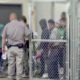Illegal migrants at a holding facility-As Biden's Border Crisis Continues as Dems Look to Blame Trump -ss-Featured