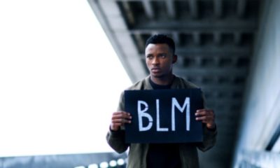 Man holding BLM sign-BLM Admits Communities Are Far Worse Off Under Biden Than Trump-ss-Featured
