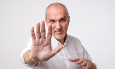 Mature man in white shirt showing sign stop with hand. Deny to do something-Denying-ss-featured