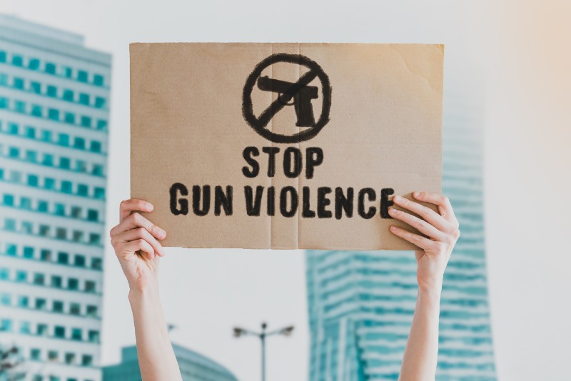 Stop gun violence phrase drawn on a carton banner in men's hand-Things to Know-ss
