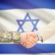 American soldier in uniform and civil man in suit shaking hands with adequate national flag on background - Israel | US Rejects UN Security Council Call For Ceasefire | Featured