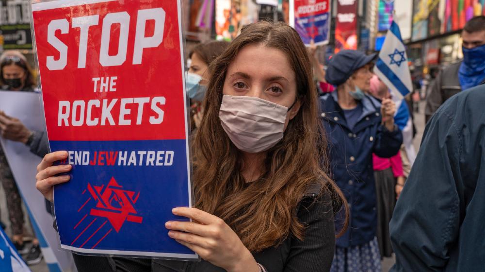 Pro-Israel supporters hold Israeli flags and sign in Times Square during a solidarity with Israel rally | Christians Help Israel, Send Portable Bomb Shelters | Featured