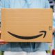 Woman receiving Amazon Prime package delivered preparing to do the unboxing, proud Amazon Prime client | Josh Hawley Says Amazon A Monopoly, Opposes MGM Buyout | Featured