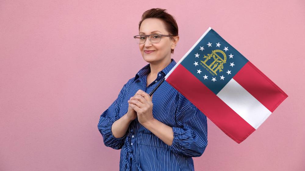Georgia flag. Woman holding Georgia state flag | Georgia Cleans Up Voters List, Will Remove 101,789 Names | featured