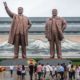 Locals and tourist in front of the Northern Korea leader statue in a cloudy day | Defector Says Woke US Schools Nuttier Than North Korea | featured