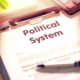 Political System on Clipboard. Office Desk with a Lot of Office Supplies | 5 Reasons Many Feel The American Political System Is Failing | featured