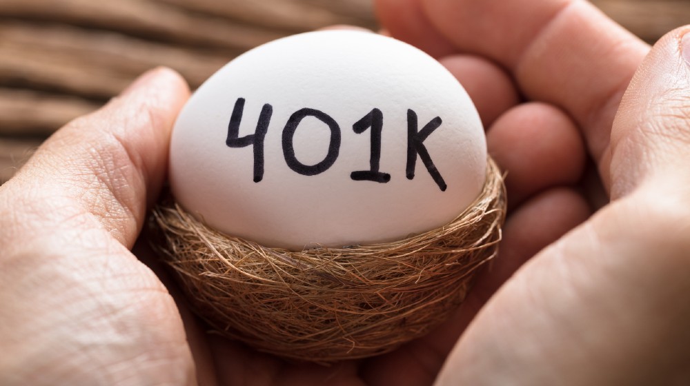 Closeup of hands holding 401K white egg in nest | What Is a 401k? | featured