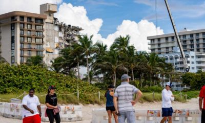 People visiting the site of the collapsed Chaplain Towers Surfside in Miami | President Biden is coming to the Surfside condo collapse site | featured