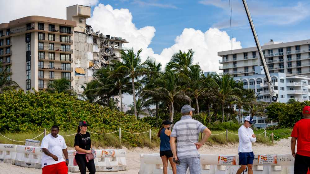 People visiting the site of the collapsed Chaplain Towers Surfside in Miami | President Biden is coming to the Surfside condo collapse site | featured