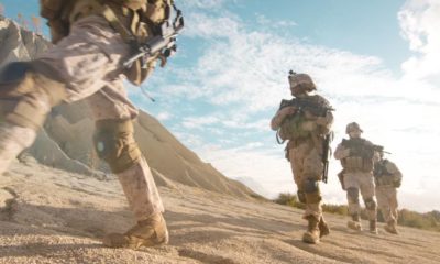 Squad of Fully Equipped and Armed Soldiers Moving in Single File in the Desert | As Taliban Advances, Biden Defends Afghanistan Pullout | featured