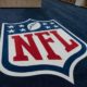 The NFL logo is displayed in the visitors locker room at Mile high Stadium in Denver Colorado | NFL 2021 Season To Feature Black National Anthem | featured