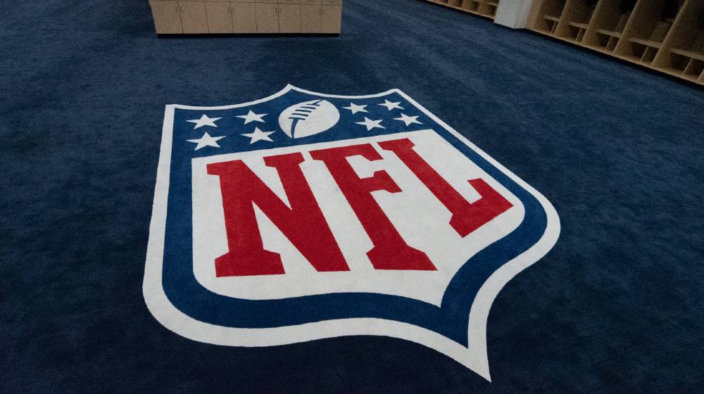 The NFL logo is displayed in the visitors locker room at Mile high Stadium in Denver Colorado | NFL 2021 Season To Feature Black National Anthem | featured