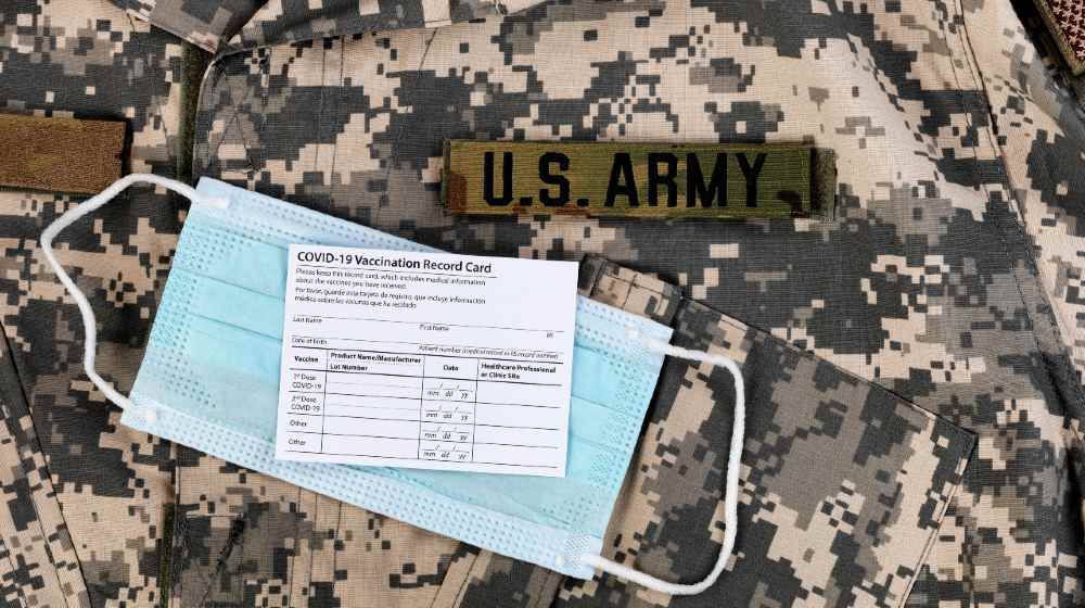 Covid 19 vaccination record card and personal facemask on US Army military uniform | Pentagon Issues COVID-19 Vaccine Mandate for Troops | featured