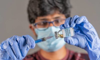 Close up of doctor hands holding covid-19 vaccine booster shot with syringe | FDA OKs Pfizer booster dose for At-Risk Americans | featured