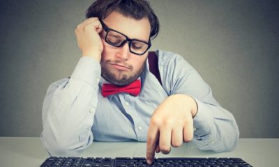 Young obese man sitting at workplace and procrastinating being lazy and distracted | Some Ways To Avoid Procrastination | featured