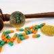 A gavel with medication and bitcoins on a white background. Medical malpractice and legal virtual currency | Get to Know About the Bitcoin Malpractices That Exist | featured
