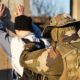 Back view of man in uniform unknown military soldier or special forces police arresting and searching criminal illegal migrant or terrorist in sunny day | Homeland Security Issues New Rules When Arresting Migrants | featured