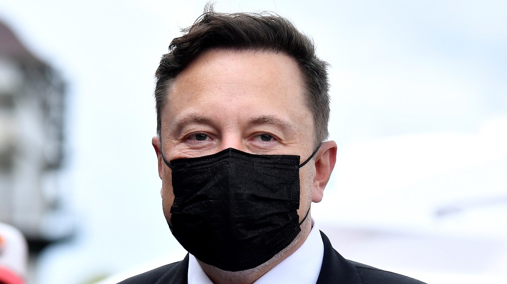 Elon Musk wears a protective mask as he arrives to attend a meeting with the leadership of the conservative | Wealthiest Person in the World Opposes Unrealized Gains Tax | featured