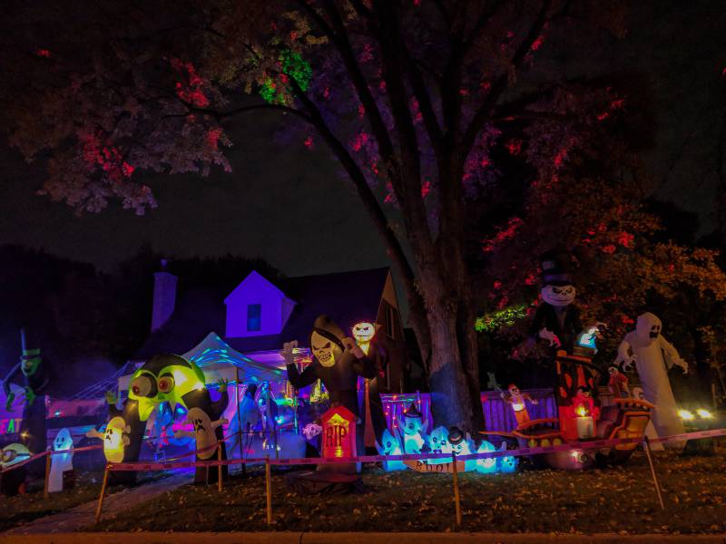 Many large glowing spooky Halloween decorations, carved pumpkins, scarecrows at front lawn of houses-Lockdown Halloween Party