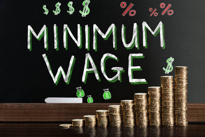 Minimum Wage At Blackboard Behind Stacked Coins-17 Minimum Wage