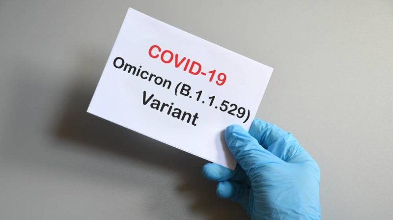 Doctor's hand in blue glove with white paper and text Covid-19 Omicron Variant | CNN 5 Things