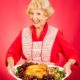 Sweet grandmother holding a beautifully cooked turkey dinner | Man Attends 6th Thanksgiving Dinner Despite Getting Wrong Invitation | featured