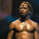 Travis Scott performing live music show concert on night club stage | 400 Victims Sue Travis Scott, AstroWorld Organizers For $750M | featured