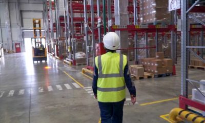 female warehouse worker with helmet and safety vest | Amazon Fined for Not Reporting COVID-19 Infections to Workers | featured