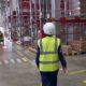 female warehouse worker with helmet and safety vest | Amazon Fined for Not Reporting COVID-19 Infections to Workers | featured