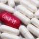 view a red pill word - COVID-19 with many white pills | UK Approves World’s First COVID Pill For Public Use | featured