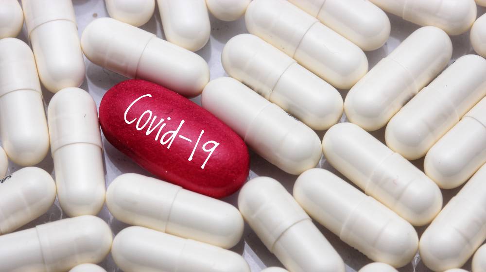 view a red pill word - COVID-19 with many white pills | UK Approves World’s First COVID Pill For Public Use | featured