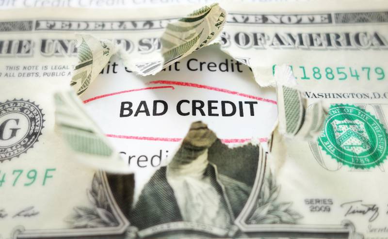 Bad Credit text under a torn dollar bill | Bad Credit Loan