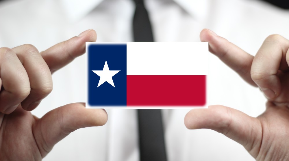 Businessman holding a business card with Texas State Flag | Texas Beats California As The Quitting Capital of the US | featured