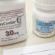 OxyContin and oxycodone bottle on counter with rx prescription pad | Judge Junks Oxycontin Settlement, Orders Sackler Family to Pay Up | featured