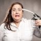 woman shooting herself with a fuel pump nozzle | Gasoline Prices To Average More Than $4 Per Gallon Next Year | featured