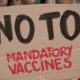 Group of no VAX deniers holding up a no to mandatory vaccines | Doubts On COVID Vaccine Fueling Bigger Anti-Vax Movement | featured