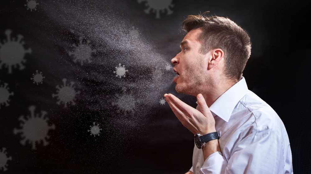 Man is coughing trying to cover his mouth. Influenza, cold, flu, coronavirus | Prior COVID Infection Gave Better Protection Than Vaccines During Delta Surge | featured